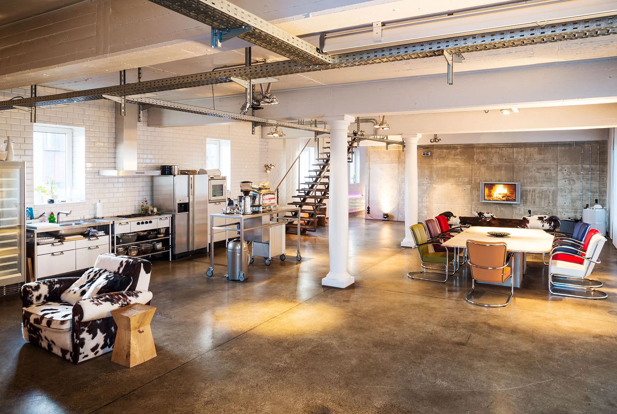 Industrieloft mit offener Küche, Esstisch und Kamin