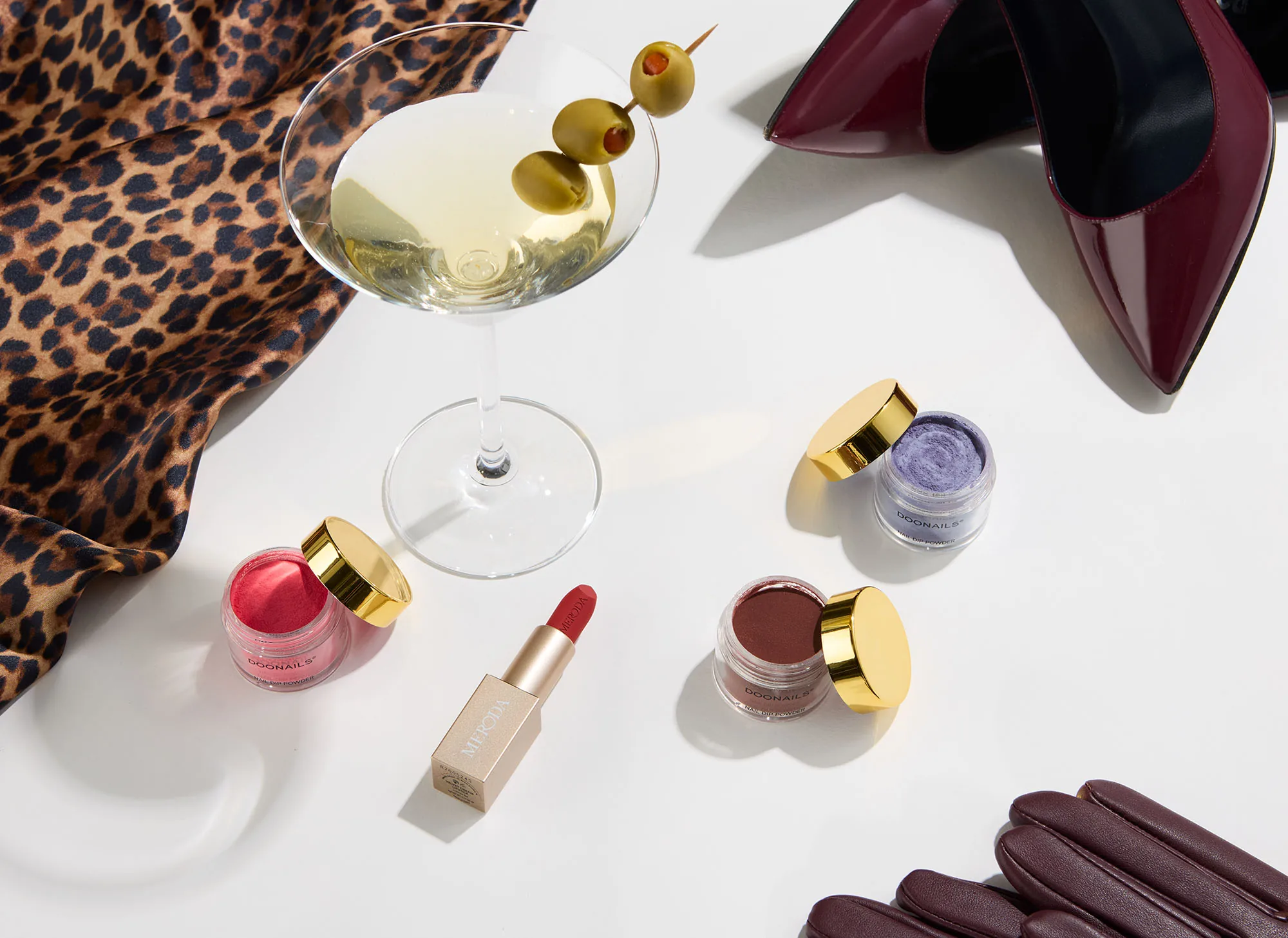 Lippenstift, Lidschatten und Martini auf Leopardenstoff